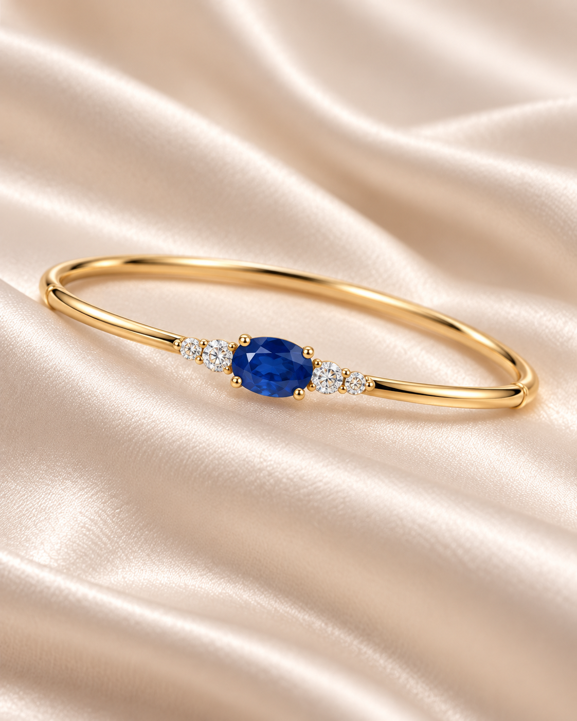 Oval blue sapphire and diamond bangle on wrist